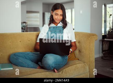 Frau, Laptop oder entspannen Sie sich auf dem Sofa im Haus oder zu Hause im Wohnzimmer für E-Learning, Bildung oder Lockdown-Lernen. Lächeln, glücklich oder Schüler über Technologie für Stockfoto