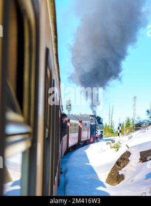 Alte Retro-Dampfeisenbahn im Winter im Schnee im Harz-Nationalpark Deutschland, Dampfeisenbahn Brocken Bahn auf dem Weg durch die Winterlandschaft, Brocken, Harz Deutschland Stockfoto