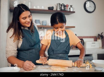 Bäckerin für Familien, Mutter und Mädchen mit einem Pfannkuchen, der beim Backen von Kuchen, Essen oder Keksen in einer Hausküche hilft. Entwicklung des Kindes, Lernen oder Zufriedenheit Stockfoto