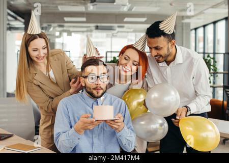 Business-Team feiert den Geburtstag des Kollegen im modernen Büro Stockfoto