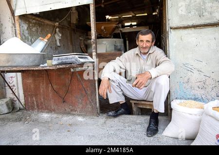 Interessante Szenen vom lokalen täglichen Markt in Ozurgeti, Mann, ein Verkäufer, der auf einem Boden sitzt, während er Mehl verkauft, Georgia Stockfoto