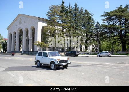 Lada Niva aus der sowjetära fährt am Ozurgeti Drama Theater in der Stadt Ozurgeti in Guria, Georgia Stockfoto