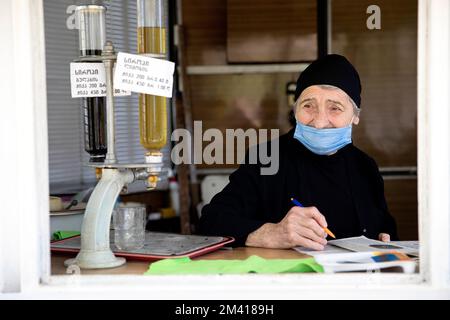 Interessante Szenen vom lokalen täglichen Markt in Ozurgeti, in der Nähe der Küste des Roten Meeres, Frau, eine Verkäuferin, die während des Verkaufs ein Buch liest, Georgia Stockfoto