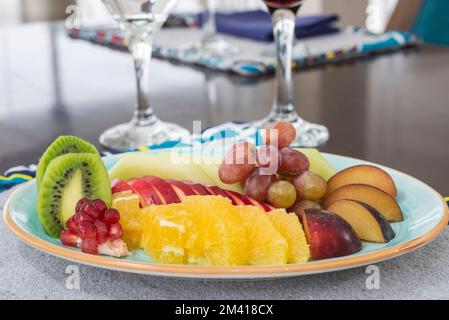 Auswahl an frischem Obst auf einem Teller am Restauranttisch Stockfoto
