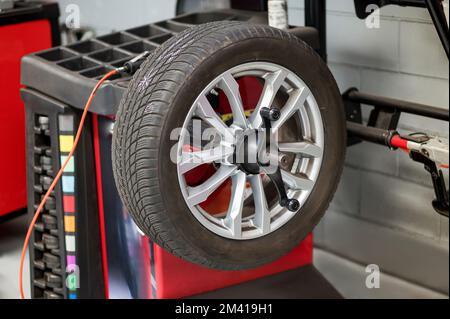 Auswuchtung der Fahrzeugräder an der Zahnstange in der Werkstatt des Reifenhändlers Stockfoto