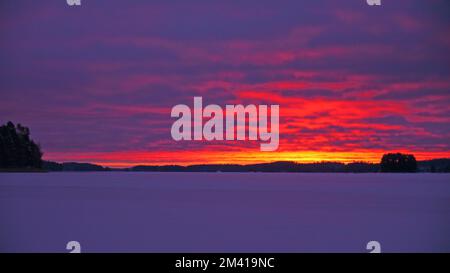 Wintermorgenglühen auf dem Suvasvesi-See. Vehmersalmi, Kuopio, Finnland, 2022-12-16 09:26 +02. Temp. -10 °C, Wind W 3 m/s. Stockfoto