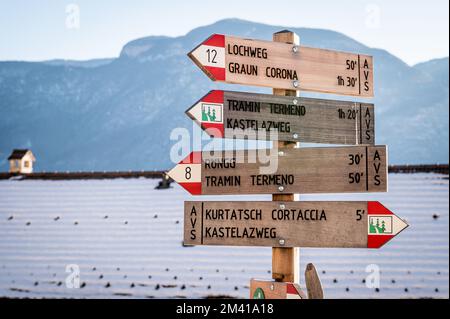 Hölzernes Fußweg-Schild weist auf öffentliche Fußwege im Dorf Cortaccia an der Weinstraße, Südtirol - Trentino Alto Adige, Norditalien hin. Stockfoto