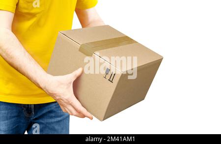 Der Zusteller in gelbem Hemd übergibt ein Paket isoliert auf Weiß. Stockfoto
