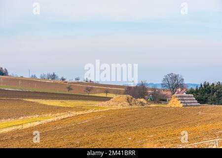 Feld- und Ackerland im Schnee. Suchen Sie nach gepflügtem Feld und Wiese Stockfoto