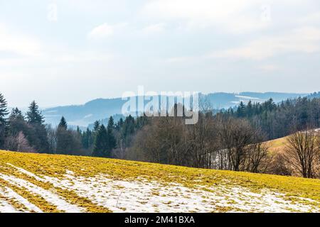 Feld- und Ackerland im Schnee. Suchen Sie nach gepflügtem Feld und Wiese Stockfoto