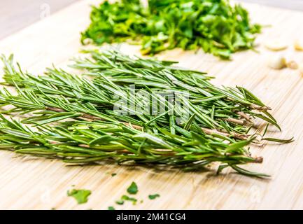 Thymian und Parley wurden mit einem Messer auf den Holztisch gelegt. Frische und gesunde Pflanzen zum Kochen zubereitet. Stockfoto