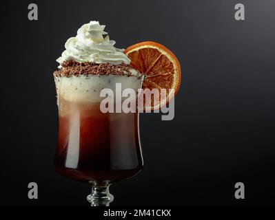 Schokoladencocktail mit Schlagsahne mit Schokoladenchips und garniert mit einer getrockneten Orangenscheibe. Speicherplatz kopieren. Stockfoto