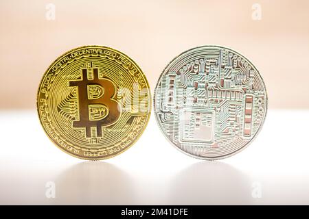 Bitcoin Gold- und Silbermünze auf weißbraunem Hintergrund. Münze von beiden Seiten - Vorder- und Rückseite. Kryptowährungssymbol. Stockfoto