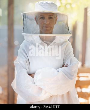 Porträt, Imker und Frau mit gekreuzten Armen auf dem Bauernhof, die sich für die Arbeit fertig machen. Führungspersönlichkeit, Bienenzucht und weibliche Kleinbauern und reife Landwirte Stockfoto