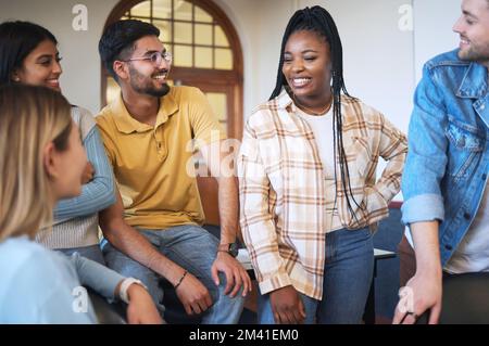 Universität, Projekt und Gruppe von Studierenden, die zu Forschungs-, Studien- oder Informationszwecken im Klassenzimmer diskutieren. Glücklich, Vielfalt und Freunde, die miteinander reden Stockfoto