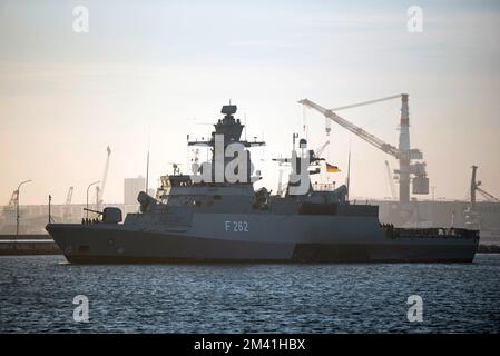 18. Dezember 2022, Mecklenburg-Vorpommern, Warnemünde: Die Corvette "Erfurt" betritt ihren Marinestützpunkt in Rostock, hohe Düne. Die deutsche Marine nimmt seit mehr als 15 Jahren an der UN-Mission im Mittelmeer Teil und übernahm im vergangenen Jahr erneut das Kommando über die Mission. Seit Oktober 2021 dient die Corvette „Erfurt“ als Plattform im Betriebsbereich. Während dieser Zeit hat das vielseitige Schiff mehr als 21.600 Seemeilen zurückgelegt. Foto: Frank Hormann/dpa Stockfoto