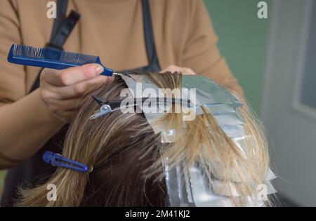 Position der Fixierung der Haare am Kopf während des Färbevorgangs. Verwendung der Folie. Ausgewählter Fokus Stockfoto