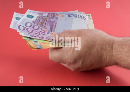 Bargeld-Wette rote Tischhand im Casino mit Stückelungen Euro-Banknoten Stockfoto