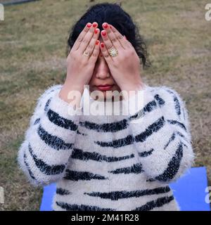 Porträt einer wunderschönen jungen Indianerin, die im Park Yoga praktiziert. Ein hübsches Mädchen übt die Yoga-Pose. Ruhe und Entspannung, weibliches Glück Stockfoto