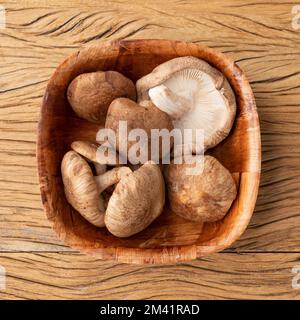 Shitake Pilze in einer Schüssel über Holztisch. Stockfoto