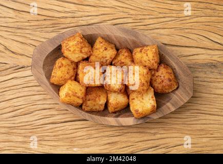 Tapiokawürfel, typisch nordöstliches brasilianisches Essen auf einem Holztisch. Stockfoto