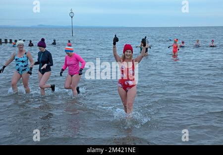 Portobello, Edinburgh, Schottland, Großbritannien. Dezember 2022. Anna Neubert-Wood und die WanderWomen-Gemeinschaft schließen sich für ein Sonnenaufgangsschwimmen zusammen und spenden der Joshua Nolan Foundation. Die Sonnenaufgangsschwimmen & Fire für die Wintersonnenwende, die dunkelste Zeit des Jahres, wurde von Anna Neubert-Wood von WanderWomen organisiert. Ziel des JNF ist es, diese Zahl zu verringern, indem er dazu beiträgt, hochwertige Beratungssitzungen für diejenigen zu finanzieren, die sie dringend benötigen, und gleichzeitig das Bewusstsein für das Thema und die verfügbare Unterstützung verbessert. Schottland. Im Bild: Sasha Udell verlässt den Firth of Forth nach der Wohltätigkeitsveranstaltung. Stockfoto