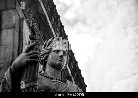 Eine Grauskala der Männerstatue unter einem wolkigen Himmel Stockfoto