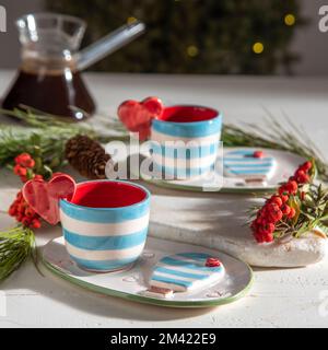 Türkische Kaffeetassen aus Keramik auf einem Tisch mit weihnachtsdekor Stockfoto