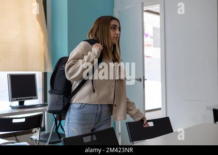 Studentin mit Rucksack im Klassenzimmer Stockfoto