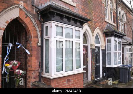 Clarence Road, Handsworth, 18. Dezember 2022. Die Polizei von West Midlands hat bestätigt, dass eine Leiche eines Kindes im Garten eines Anwesens an der Clarence Road in Handsworth, Birmingham, gefunden wurde. Die Polizei ist weiterhin auf dem Terrassengrundstück stationiert, wo florale Tribut an einem Tor, das zu den hinteren Gärten führt, hinterlassen wurden. Ein Grundstück hinter dem Haus wurde mit brauner Plane bedeckt, die den Tatort bedeckt. Ein 40- und 41-jähriger Mann wurde wegen Vernachlässigung angeklagt, weil er den Tod eines Kindes verursacht oder zugelassen hat. Quelle: Stop Press Media/Alamy Live News Stockfoto