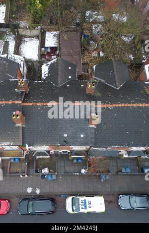 Clarence Road, Handsworth, 18. Dezember 2022. Die Polizei von West Midlands hat bestätigt, dass eine Leiche eines Kindes im Garten eines Anwesens an der Clarence Road in Handsworth, Birmingham, gefunden wurde. Die Polizei ist weiterhin auf dem Terrassengrundstück stationiert, wo florale Tribut an einem Tor, das zu den hinteren Gärten führt, hinterlassen wurden. Ein Grundstück hinter dem Haus wurde mit brauner Plane bedeckt, die den Tatort bedeckt. Ein 40- und 41-jähriger Mann wurde wegen Vernachlässigung angeklagt, weil er den Tod eines Kindes verursacht oder zugelassen hat. Quelle: Stop Press Media/Alamy Live News Stockfoto