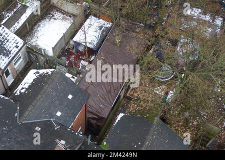 Clarence Road, Handsworth, 18. Dezember 2022. Die Polizei von West Midlands hat bestätigt, dass eine Leiche eines Kindes im Garten eines Anwesens an der Clarence Road in Handsworth, Birmingham, gefunden wurde. Die Polizei ist weiterhin auf dem Terrassengrundstück stationiert, wo florale Tribut an einem Tor, das zu den hinteren Gärten führt, hinterlassen wurden. Ein Grundstück hinter dem Haus wurde mit brauner Plane bedeckt, die den Tatort bedeckt. Ein 40- und 41-jähriger Mann wurde wegen Vernachlässigung angeklagt, weil er den Tod eines Kindes verursacht oder zugelassen hat. Quelle: Stop Press Media/Alamy Live News Stockfoto