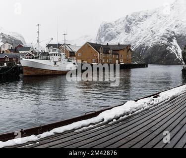 Fischerboot im Hafen bei Schneefall, Norwegen Stockfoto