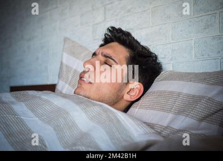 Schönen jungen krank oder unwohl Mann im Bett mit einer Grippe oder Fieber Stockfoto