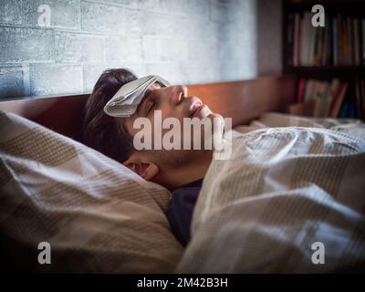 Schönen jungen krank oder unwohl Mann im Bett mit einer Grippe oder Fieber Stockfoto