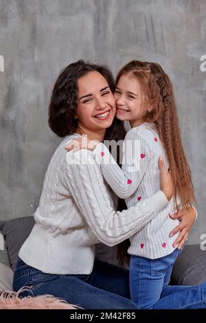 Emotionen einer jungen, schönen Mutter und ihrer kleinen Tochter, die Zeit miteinander verbringen. Sie zeigen Liebe füreinander Stockfoto