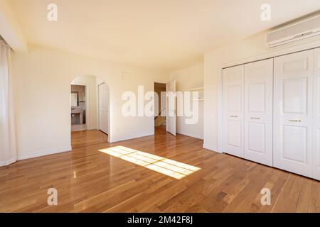 Großes Schlafzimmer mit eingebauten Kleiderschränken, begehbarer Schrank, der zu einem en-Suite Badezimmer in einem zweistöckigen freistehenden Haus führt Stockfoto