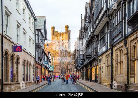 Blick auf die Kathedrale von Chester entlang der St. Werburgh Street während der Weihnachtsbeleuchtung mit Weihnachtseinkaufsmöglichkeiten Stockfoto