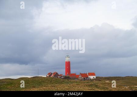 Der Leuchtturm Eierland und einige weiße Häuser mit gelesenen Ziegeldächern in den Dünen auf der niederländischen Insel Texel im Waddenmeer Stockfoto