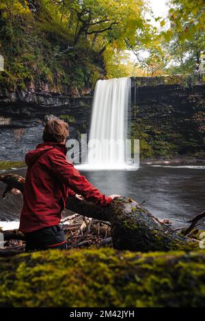 Mann mit Blick auf Sgwd Gwladys oder Lady Falls entlang des Four Waterfalls Walk, Waterfall Country, Brecon Beacons National Park, South Wales, Großbritannien. Stockfoto