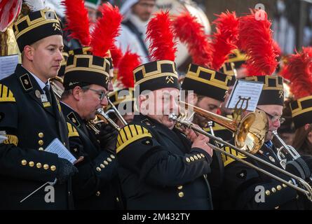 18. Dezember 2022, Sachsen, Annaberg-Buchholz: Teilnehmer der großen Bergparade spielen bei frostigen Temperaturen während des Abschlusskonzerns vor dem St. Die Annen-Kirche. Die Bergparade in der Stadt Erzgebirge markiert traditionell das Ende der Reihe von Bergparaden vor Weihnachten, die von der Sächsischen Staatlichen Vereinigung der Bergarbeiter, Eisenarbeiter und Bergarbeiter organisiert wurden. Etwa 1.200 Menschen in traditionellen Kostümen, darunter etwa 330 Bergleute aus Sachsen und anderen Bergbauregionen der Bundesrepublik, nahmen am Höhepunkt des Bergbaujahres im Erzgebirge Teil. Foto: Kristin Schmi Stockfoto