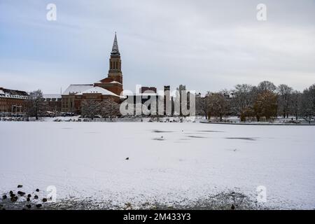 Zugefrorener und Schnee Bedeckter See in der Innenstadt Kiels mit Blick auf das Rathaus und des Opernhauses im Dezember Stockfoto