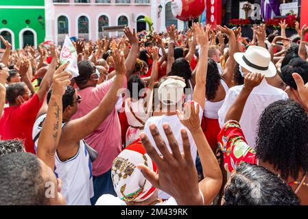 Salvador, Bahia, Brasilien - 04. Dezember 2022: Gläubige Katholiken von Santa Barbara erheben ihre Waffen zum Himmel zu Ehren des Weihnachtsmanns. Pelourinho, Salvador, Ba Stockfoto