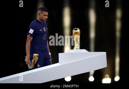 Der französische Kylian Mbappe sieht deprimiert aus, wenn er an der Trophäe der FIFA-Weltmeisterschaft vorbeigeht, nachdem er im Finale der FIFA-Weltmeisterschaft im Lusail Stadium in Katar die Niederlage Argentiniens erlitten hatte. Foto: Sonntag, 18. Dezember 2022. Stockfoto