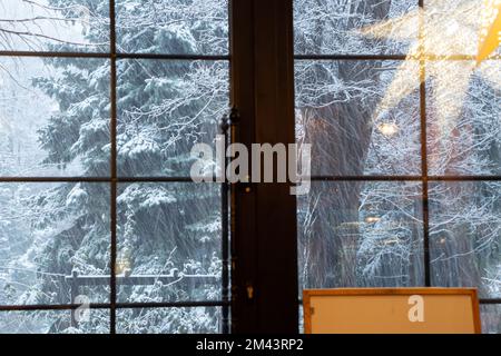 In einer Stadt in der Ukraine fällt tagsüber Schnee aus dem Fenster, Blick vom Fenster auf einen Schneesturm Stockfoto