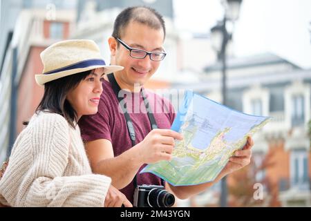 Glücklicher Multi-ethnischer Reisender, Paar Sightseeing-Stadt mit Karte. Stockfoto