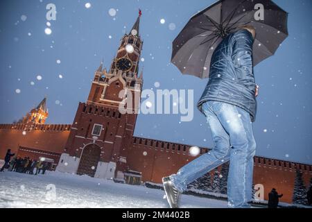 Moskau, Russland. 18.. Dezember 2022. Menschen gehen auf dem Roten Platz im Hintergrund des Spasskaja-Turms des Moskauer Kremls während des abnormalen Schneefalls im Zentrum von Moskau, Russland Stockfoto