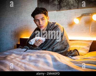 Junger Mann, der sich die Nase mit Taschentuch putzt Stockfoto