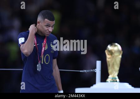 Doha, Katar. 18.. Dezember 2022. Frankreichs Stürmer Nr. 10 Kylian Mbappe sieht sich die Trophäe an, nachdem er während der Trophäenzeremonie der Katar-Weltmeisterschaft 2022 die Silbermedaille erhalten hat, nachdem er am 18. Dezember 2022 im Lusail-Stadion in Lusail, nördlich von Doha, das Fußballfinalspiel zwischen Argentinien und Frankreich verloren hat. Argentinien gewann beim Elfmeterschießen: Brasilien Photo Press/Alamy Live News Stockfoto