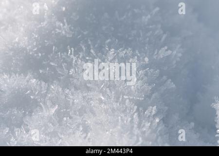 Winterhintergrund mit Sonnenlicht auf detailliertem Schnee Stockfoto